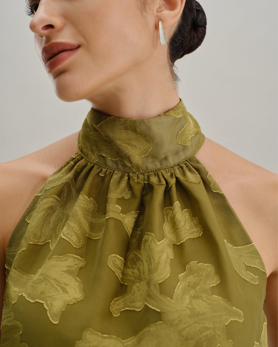 Top sin mangas verde floral con cuello tipo tortuga